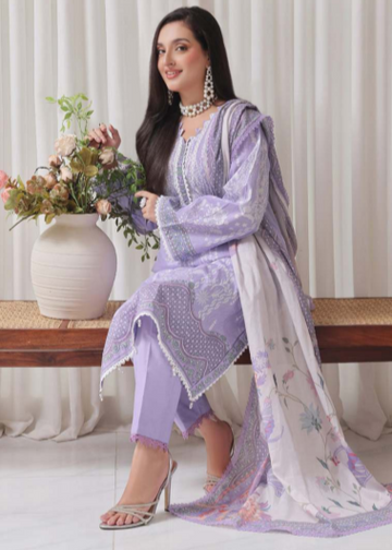 Woman in a lavender traditional outfit with a white dupatta, sitting on a bench with flowers and a vase.
