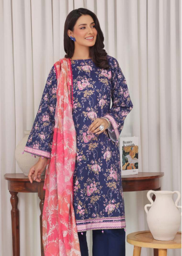 Woman wearing a navy blue floral dress with a pink dupatta in a room setting.