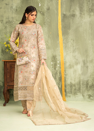 Woman in traditional outfit with floral design against a textured wall.