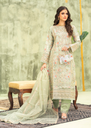 Woman in a light green embroidered outfit with a sheer dupatta, standing against a neutral background.