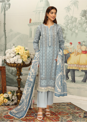 Woman in a light blue embroidered outfit standing in a decorated room with floral arrangements and classical architecture.