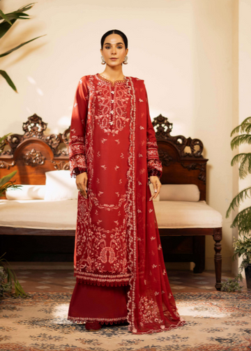 Woman wearing a red embroidered traditional outfit in a decorated room.