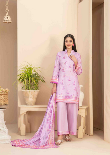 Woman wearing a light pink traditional outfit with floral patterns in a minimalistic room.