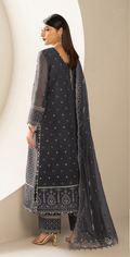 Woman wearing a dark blue embroidered traditional outfit with a beige background