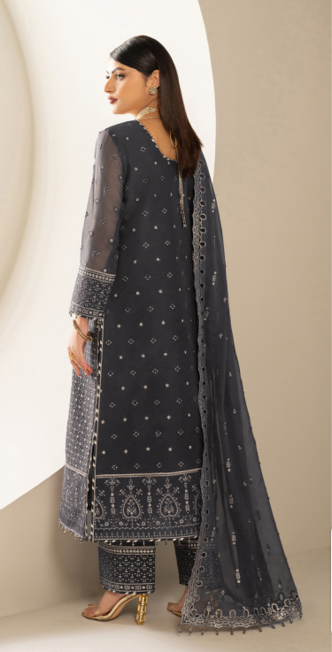 Woman wearing a dark blue embroidered traditional outfit with a beige background