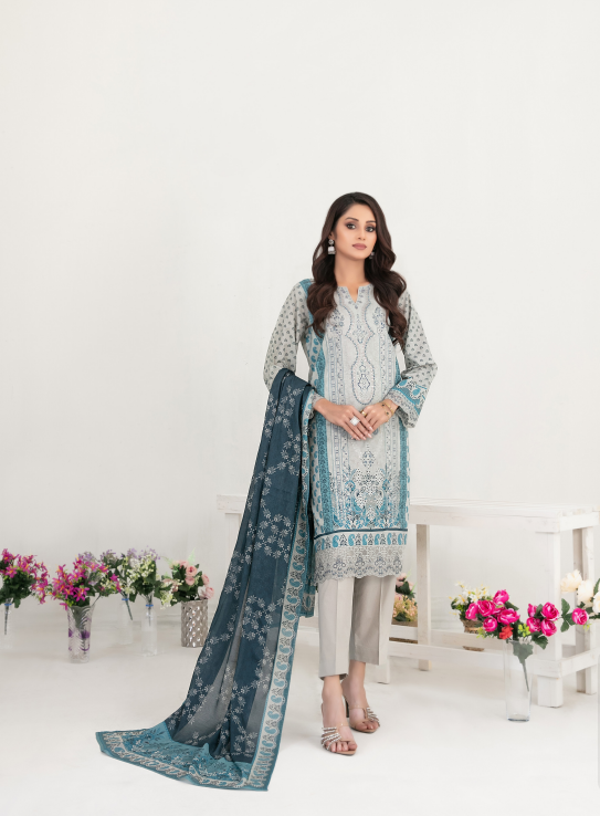 Woman wearing a traditional outfit with a blue and white dupatta in a decorated room.