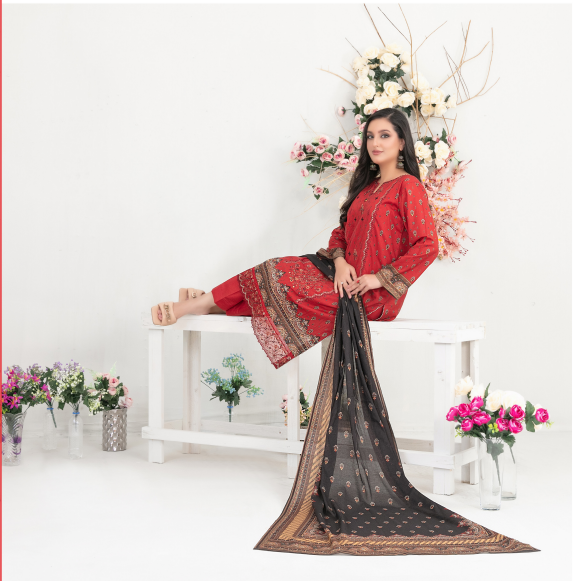 Woman in a red traditional outfit with a black dupatta sitting on a white bench with floral decorations.
