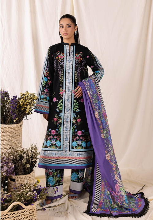 Woman wearing a black embroidered outfit with a purple dupatta against a white curtain background.