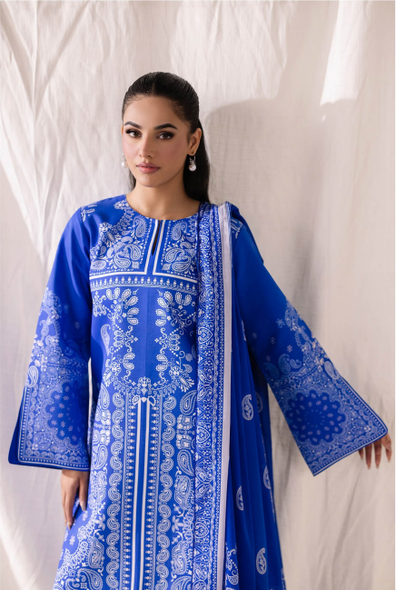 Woman wearing a blue embroidered traditional outfit against a white background