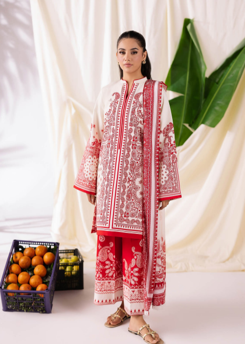Woman wearing a red and white embroidered traditional outfit with a white curtain and fruit basket in the background.
