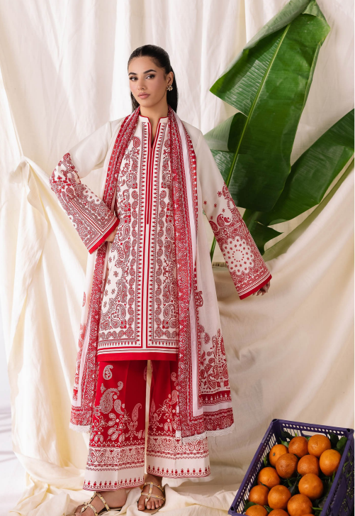 Woman wearing a red and white embroidered traditional outfit with a white curtain and green leaves in the background.