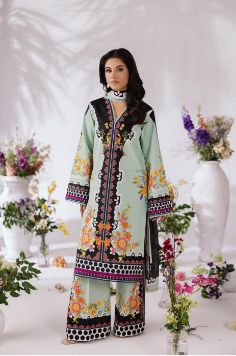 Woman wearing a traditional outfit with floral patterns in a decorated setting with flowers and vases.