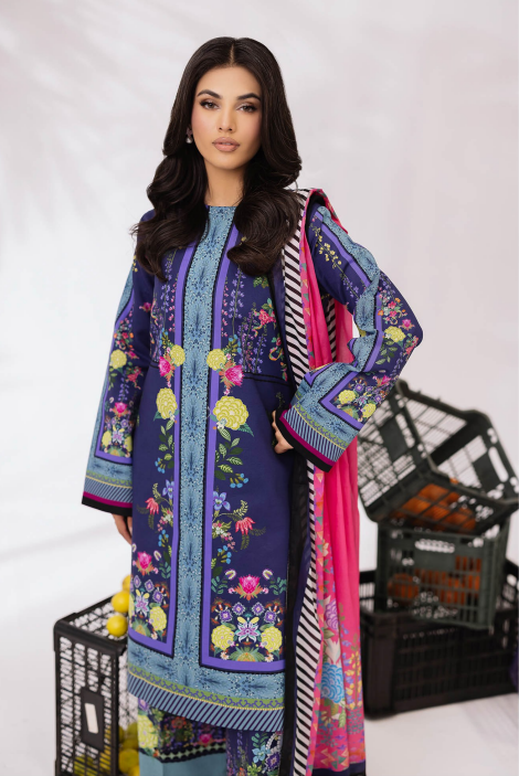 Woman wearing a colorful embroidered dress with a pink dupatta, standing against a white background.