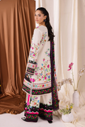 Woman wearing a traditional embroidered outfit with a colorful shawl against a neutral background