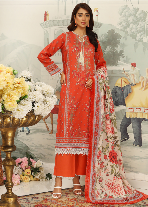 Woman in a red embroidered outfit with a floral dupatta, standing in a decorated room with flowers and furniture.
