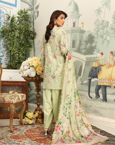 Woman in a light green traditional outfit with floral patterns in an ornate setting.