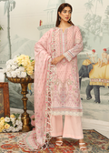 Woman in a pink traditional outfit standing in a decorated room with floral arrangements and an elephant painting.