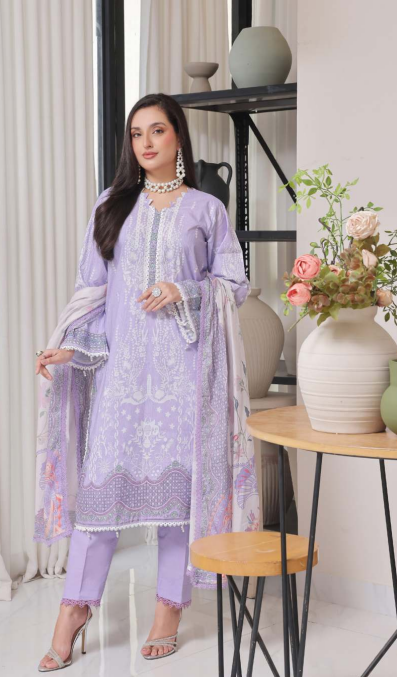 Woman in a light purple outfit with floral patterns in a modern interior setting.