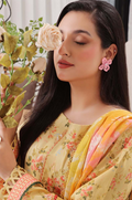 Woman in a floral saree holding a flower, wearing pink earrings.