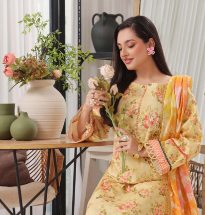 Woman in a floral dress holding flowers in a home setting with decor elements.