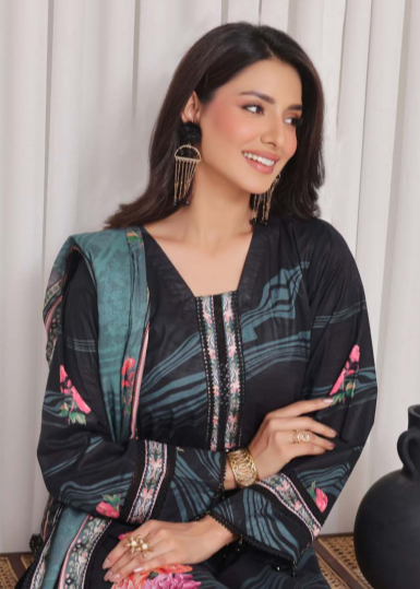 Woman wearing a black and green floral dress with a white curtain background