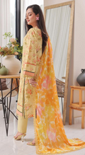 Woman in a yellow floral outfit with a matching dupatta in a room with a mirror and decor.