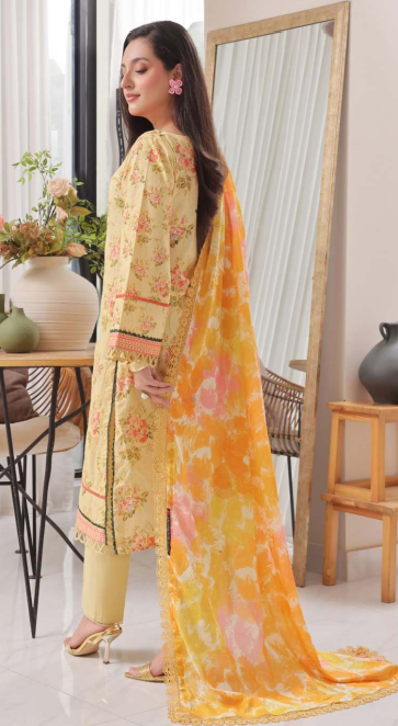 Woman in a yellow floral outfit with a matching dupatta in a room with a mirror and decor.