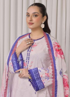 Woman wearing a light pink floral saree with a blue border against a white curtain background