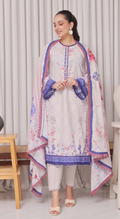 Woman wearing a floral embroidered outfit with a matching dupatta in a room setting.