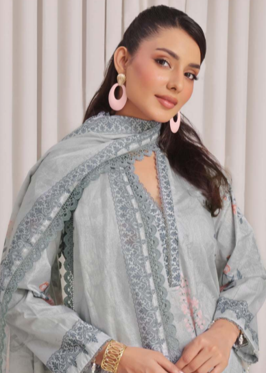 Woman wearing a light gray embroidered outfit with a matching dupatta against a white background