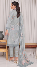 Woman wearing a light blue embroidered outfit with a matching dupatta in a room setting.