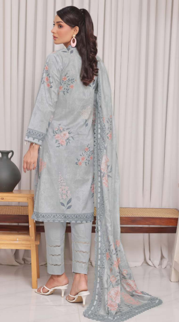 Woman wearing a light blue embroidered outfit with a matching dupatta in a room setting.