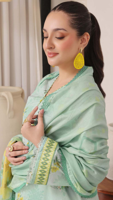 Woman wearing a light green saree with yellow accents indoors