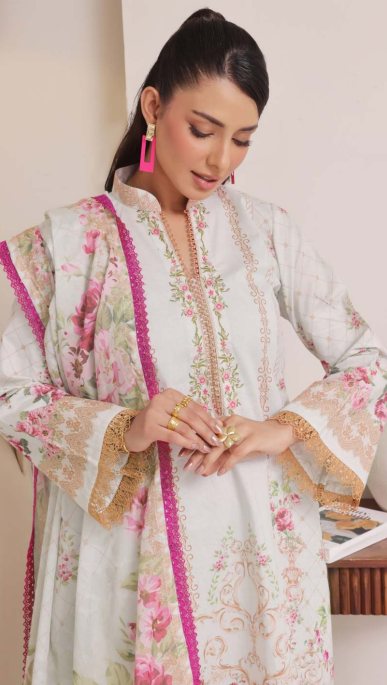 Woman wearing a floral dress with pink and gold accents indoors.