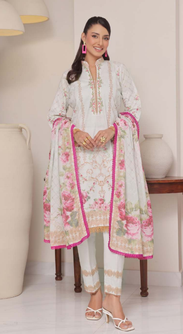 Woman wearing a white and pink traditional outfit with floral patterns indoors.