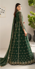 Woman wearing a green embroidered traditional outfit with a plain background