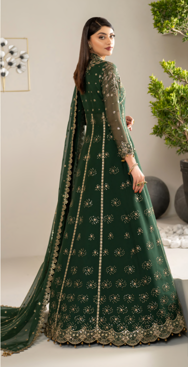 Woman wearing a green embroidered traditional outfit with a plain background