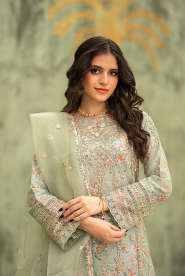 Woman wearing a light green embroidered outfit against a blurred natural background