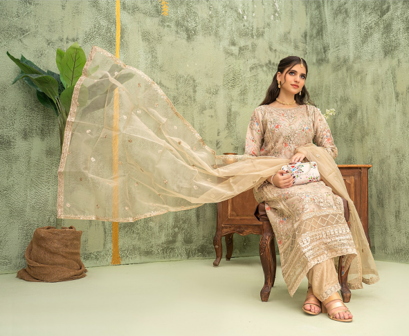 Woman in traditional outfit with a flowing fabric against a textured wall.