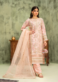 Woman wearing a traditional outfit with a floral top and beige dupatta against a textured wall.