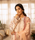 Woman in a traditional outfit with floral patterns in a softly lit room.