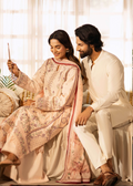 Man and woman in traditional attire sitting together, holding a phone.