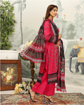 Woman in a pink traditional outfit with a patterned dupatta in a decorated room.