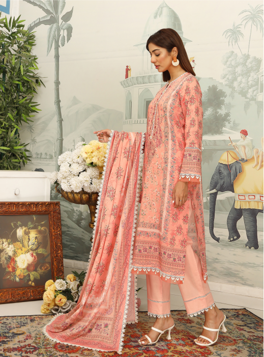 Woman in a pink embroidered outfit standing in a decorated room with flowers and an elephant painting.