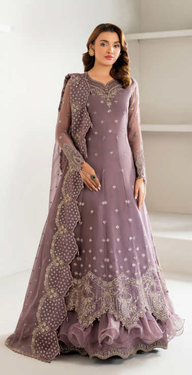 Woman wearing a mauve embroidered traditional outfit on a white background