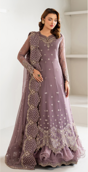 Woman wearing a purple embroidered dress with a white background