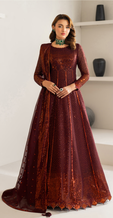 Woman wearing a long burgundy dress with a matching shawl indoors.