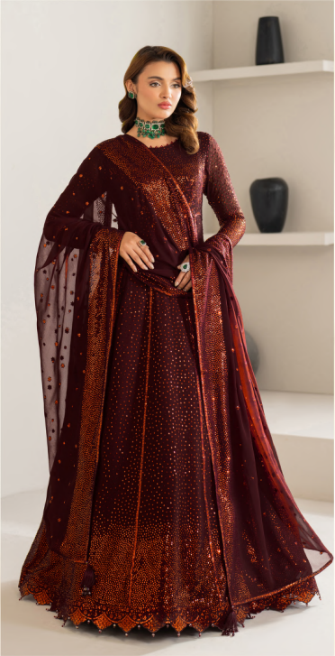 Woman wearing a maroon traditional outfit with a sheer dupatta against a white background