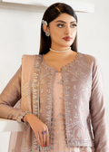 Woman wearing a beige embroidered outfit with a white background
