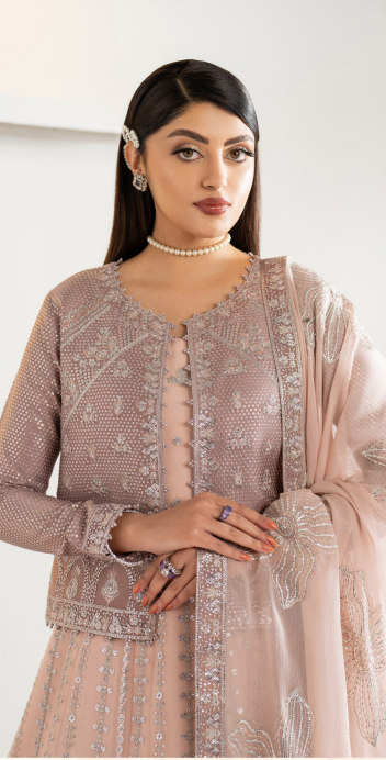 Woman wearing a traditional outfit with intricate patterns on a plain background